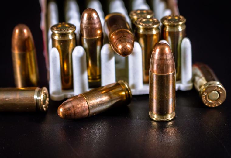 Copper jacketed rimfire cartridges standing in front of their boxes