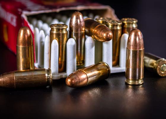 Rifle cartridges arranged beside an ammunition box